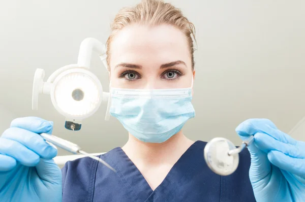 Beautiful woman dentist holding dental tools being ready for exa — Stock Photo, Image