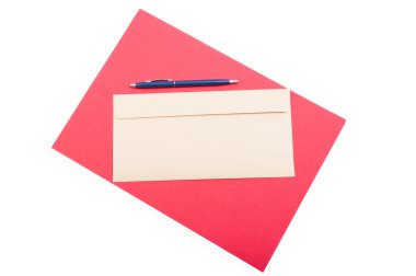 Üst görünümde kırmızı arka plan üzerinde klasik zarf ve kalem 