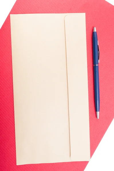 Lege envelop en pen op rode achtergrond Stockafbeelding
