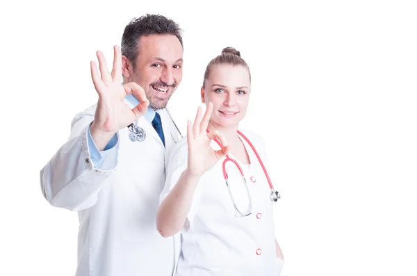 Friendly doctors acting confident and showing ok hand sign — Stock Photo, Image