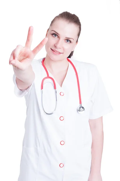 Ładna kobieta lekarz robi pokoju lub zwycięstwo gest — Zdjęcie stockowe