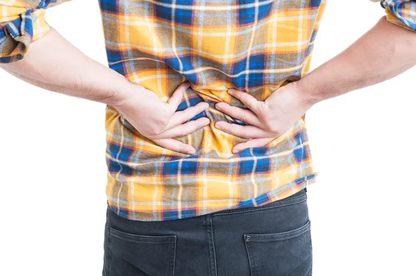 Junger Mann greift nach dem Rücken wegen Schmerzen im Lendenwirbelbereich — Stockfoto