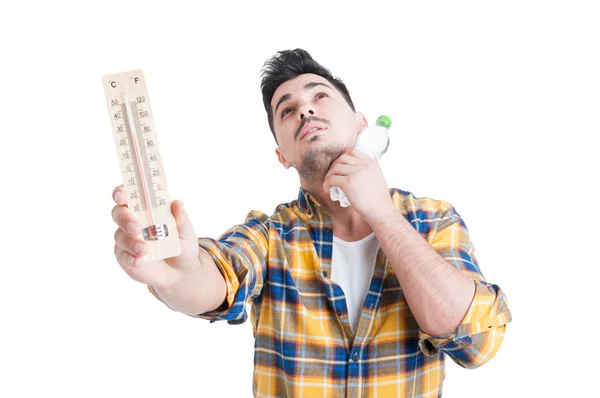 Concept of summer high temperature with man holding thermometer — Stock Photo, Image