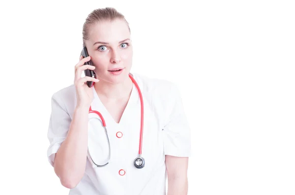 Ärztin telefoniert und wirkt überrascht — Stockfoto