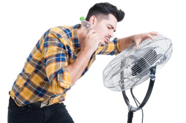 Fan duran ve serinlemek terli ve susamış bir adam