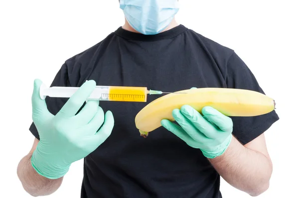 Genetically modified banana and syringe in male hands — Stock Photo, Image