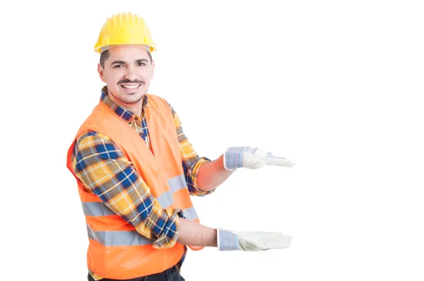 Construtor alegre mostrando algo pequeno com as mãos — Fotografia de Stock