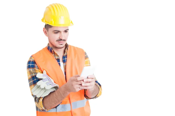 Ingeniero guapo escribiendo algo en su teléfono inteligente blanco —  Fotos de Stock