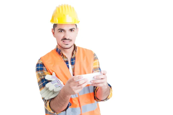 Retrato de un joven constructor con un celular en sus manos — Foto de Stock