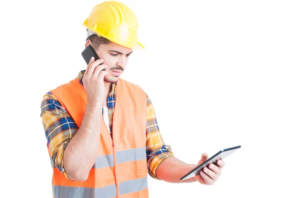 Multitasking concept with young constructor holding a tablet and — Stock Photo, Image