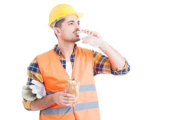 Portrét mladého inženýra, který jedl sendvič a pitnou vodu — Stock fotografie