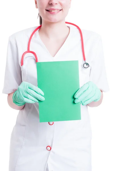 Cheerful woman doctor holding a blank green cardboard — Stock Photo, Image