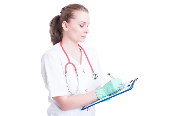 Serious and confident woman doctor writing something on cardboar — Stock Photo, Image