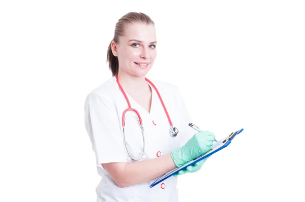 Cheerful woman doctor or surgeon holding a clipboard and write — Stock Photo, Image