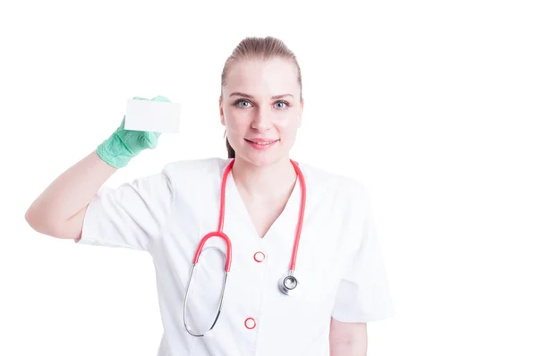 Молодая женщина-врач улыбается с визиткой в руке — стоковое фото