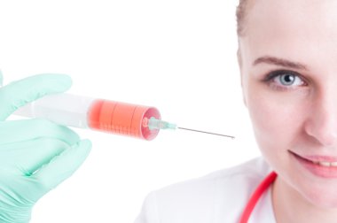Sıvı bir şırınga tutarak gülümseyen kadın doktor closeup