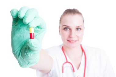 Genç kadın doktor elinde kırmızı ve sarı kapsül