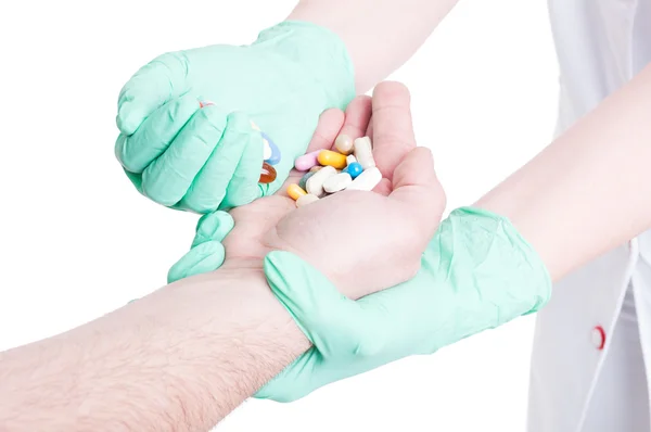 Médecin féminin donnant diverses pilules à un patient masculin — Photo