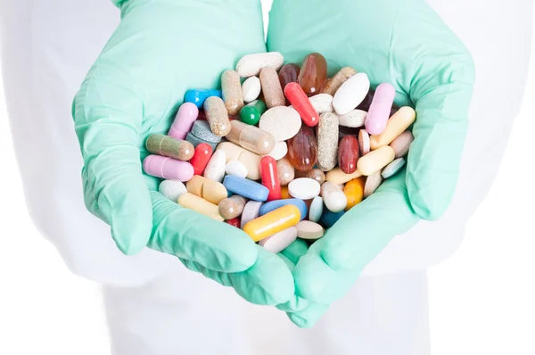 Zbliżenie: wiele tabletek, kapsułek i tabletek w ręce lekarza — Zdjęcie stockowe