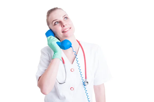 Cheerful woman doctor talking to a classic blue phone — Stock Photo, Image