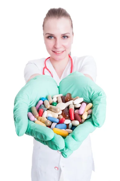 Young smiling doctor holding many pills in her palms — Stock Photo, Image