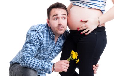 Meraklı baba ile kulak hamile eşi karın üzerinde ayakta