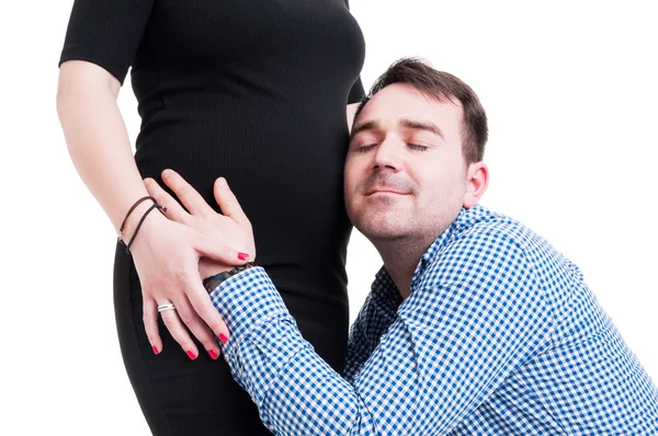 Närbild porträtt av ung man kramar hans gravida fru bel — Stockfoto