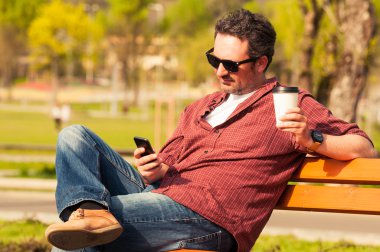 Genç hipster adam dışarıda parkta ayakta