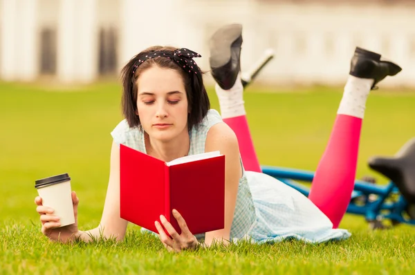 Bella giovane donna che legge un libro e si gode un caffè — Foto Stock