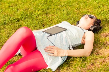 Genç kadın, tablet ve müzik kulaklık