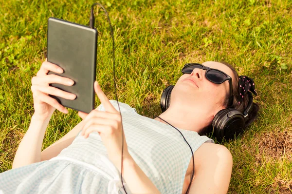 Dijital tablet parkta güneşli günde tutan güzel kadın — Stok fotoğraf