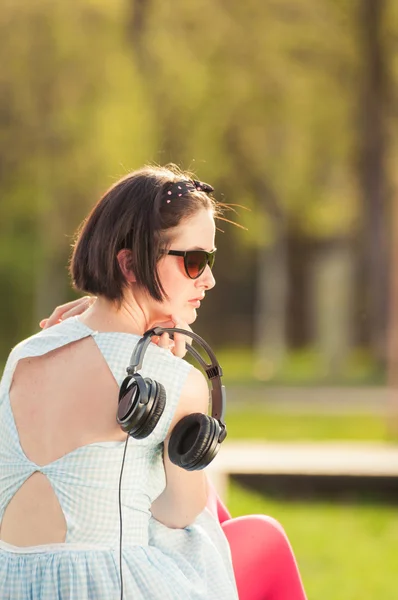 Zbliżenie: hipster młoda kobieta z zestawu słuchawkowego w parku — Zdjęcie stockowe