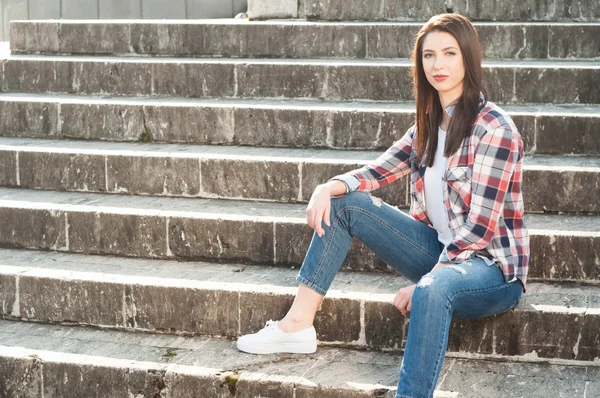 Rahat kıyafetler içinde dışında merdivenlerde oturan genç hippi erkek