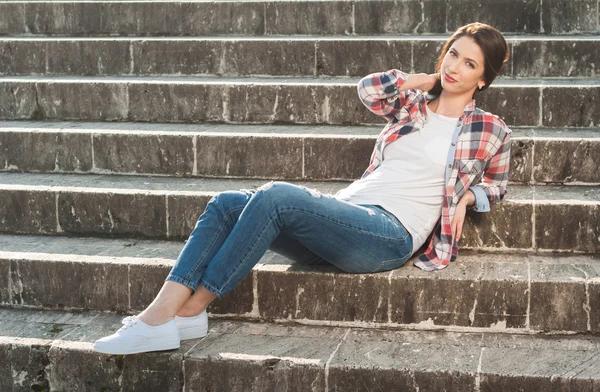 Menina bonita posando em escadas vestindo roupas casuais — Fotografia de Stock