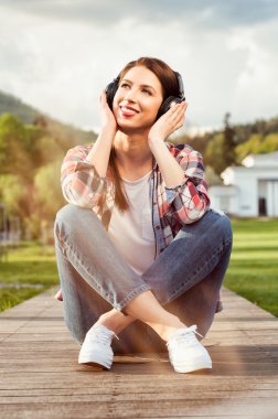 Bacaklar ile duran neşeli kadın geçti ve müziğin keyfini çıkarın