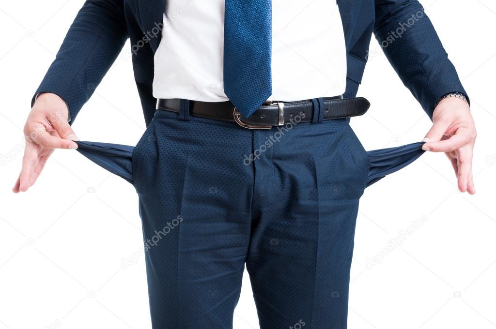 Poor businessman showing empty pants pockets