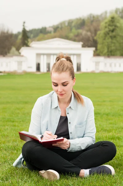 Mooie vrouw schrijven in haar dagboek zittend in Park — Stockfoto