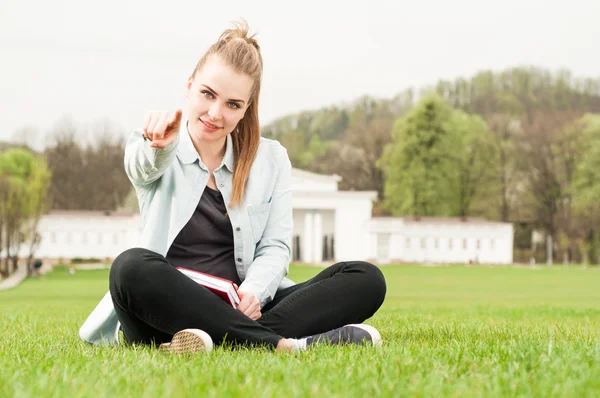 Young smiling girl pointing finger at you in the park — Stock fotografie