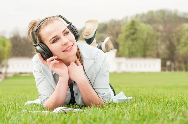 Young happy girl with headphones listening music — Stok fotoğraf