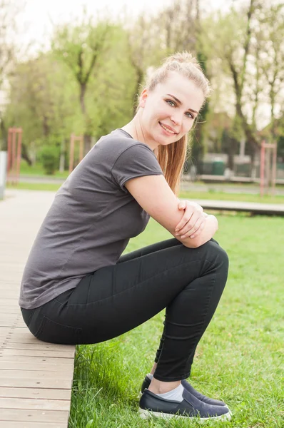 Souriante femme heureuse assise et relaxante dehors dans la nature — Photo