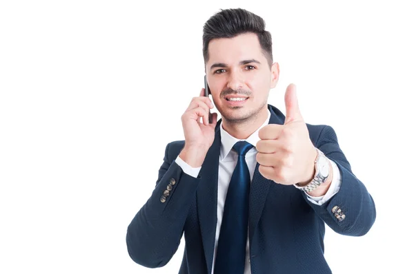 Joven empresario exitoso hablando en el teléfono inteligente y mostrando t —  Fotos de Stock