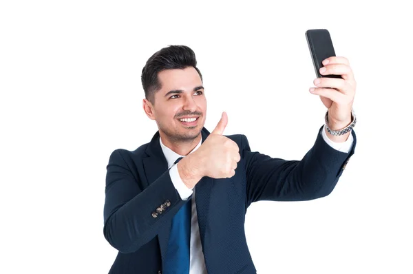 Empresário feliz fazendo uma selfie e mostrando o polegar para cima — Fotografia de Stock