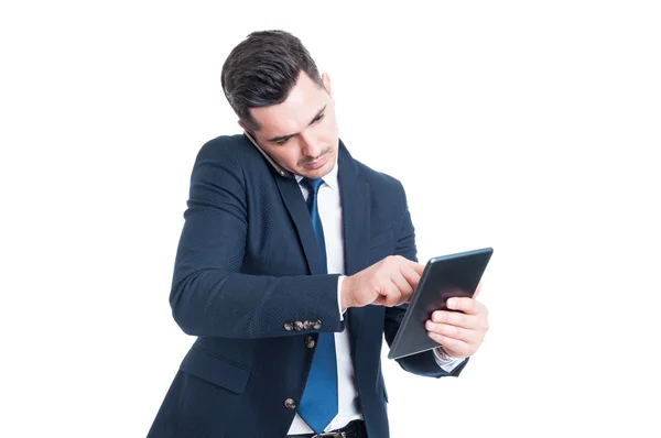 Retrato del hombre de negocios hablando por celular y trabajando en tabl — Foto de Stock