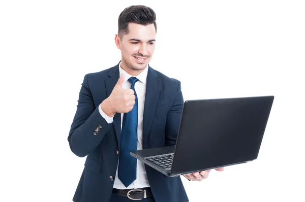 Joyful jovem vendedor segurando laptop e polegar para cima — Fotografia de Stock