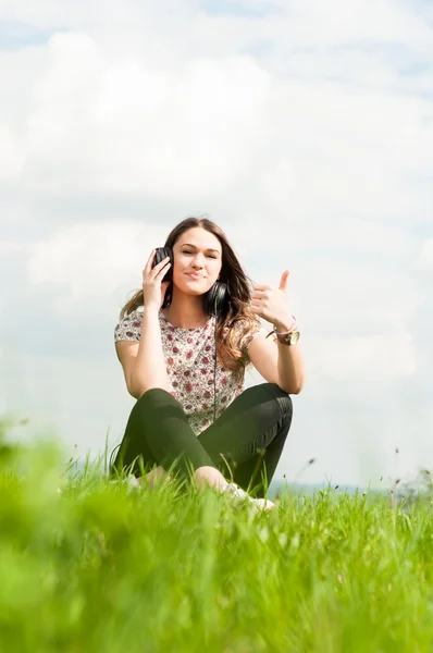 Retrato de menina alegre thumbup e relaxante no prado — Fotografia de Stock