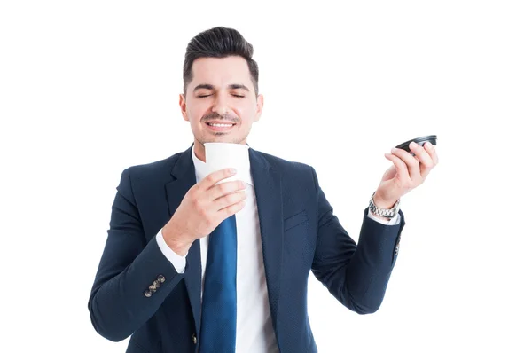 Bello venditore felice che annusa una tazza di caffè fresco — Foto Stock