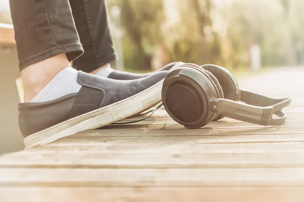 Close-up of woman legs relaxing outside near headphones — Stock Photo, Image