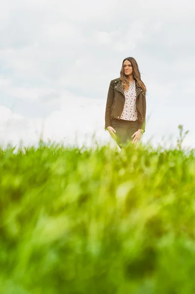 Young happy woman standing outside in green field — Stock Photo, Image