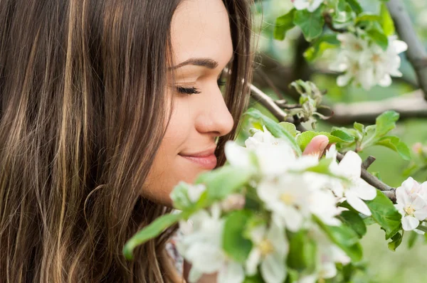 Portrait rapproché d'une heureuse femelle debout dans un verger en fleurs — Photo