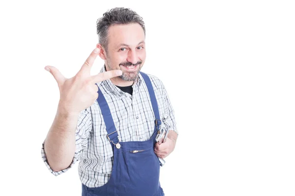 Glücklich lächelnder Mechaniker hält Schraubenschlüssel in der Hand und zählt drei — Stockfoto